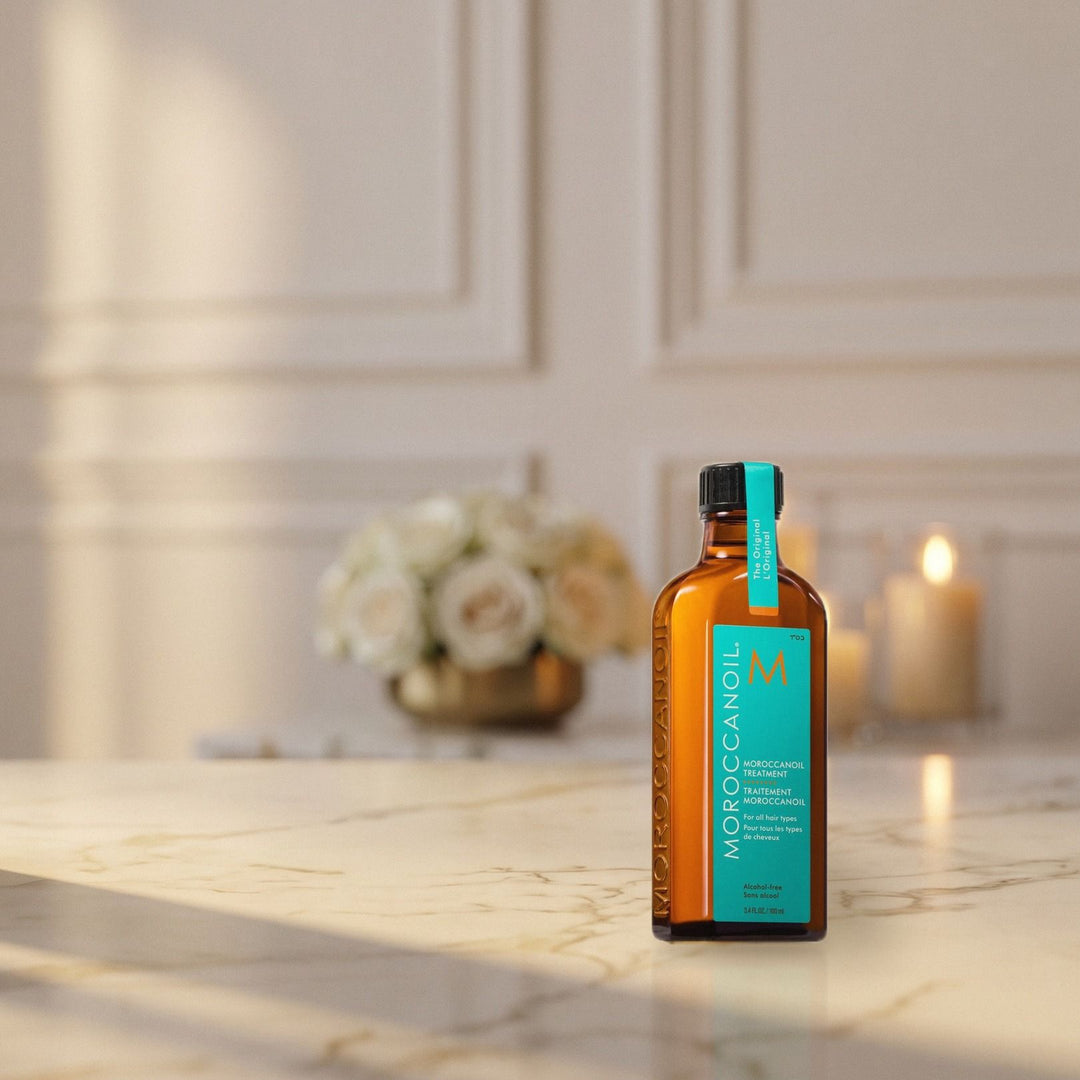 Moroccanoil Treatment Oil na marmurowym blacie przy świecach